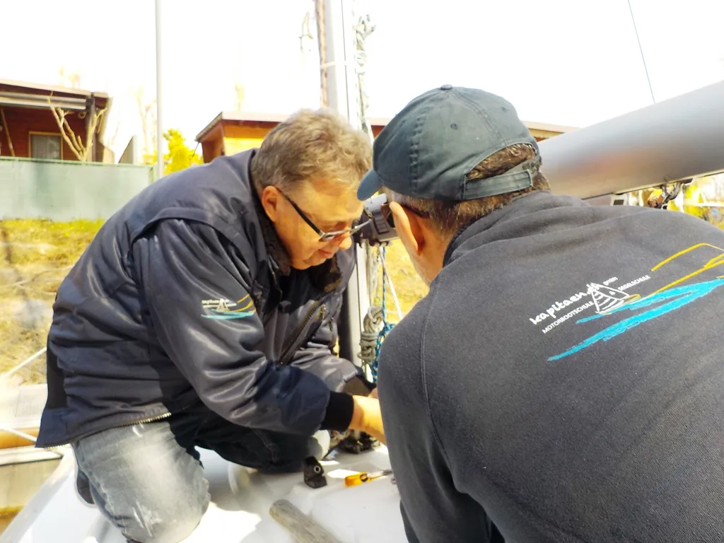 Zwei Personen arbeiten im Cockpit eines Motorboots zusammen